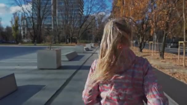 A girl runs on the sidewalk in the city of Lublin in the morning. — Video