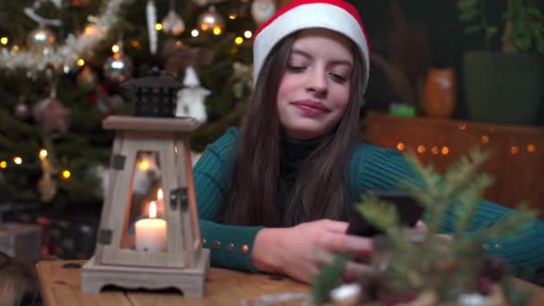 Satisfied teenager greets on cell phone in Christmas World. — Vídeo de Stock