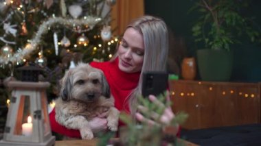 Bir kadın akıllı telefonla konuşan bir köpeği başka bir arayanla gösterir..