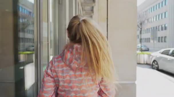 While running, a woman speeds up her pace. A blonde woman is playing sports. — Vídeo de stock