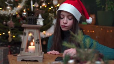 The girl looks again and again at the cell phone.