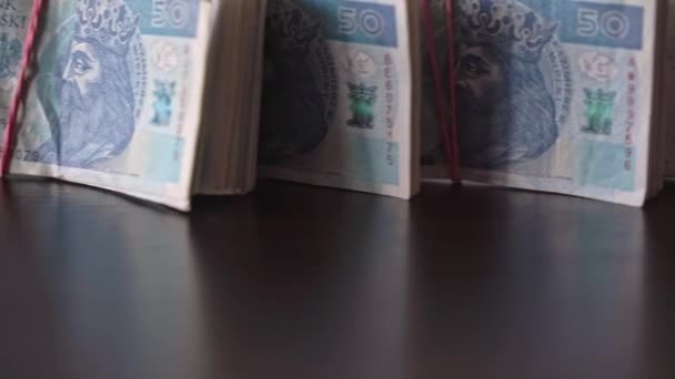 An array of fifty-dollar bills bound together with a rubber band. — Stockvideo