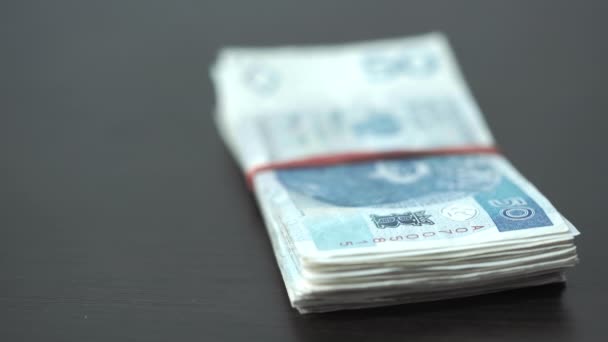 Files of banknotes tied together with a rubber band are thrown on the table. — Stockvideo