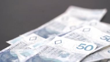A close-up view of the falling fifty zloty Polish banknotes.