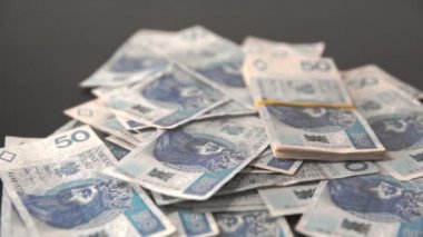 Paketlenmiş Polonya 50 zlotluk banknotları gevşek banknotların üzerine düşüyor..