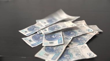 Paper money worth fifty Polish zlotys falls from above.