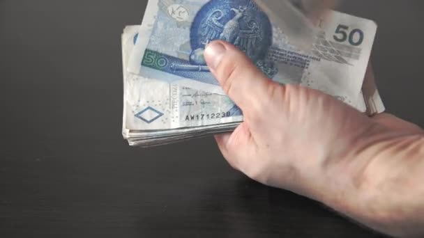 En sus manos, el hombre cuenta cincuenta billetes de zloty polacos. — Vídeos de Stock