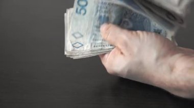 Masanın üzerindeki elinizdeki banknotları saymak. Polonya parası.