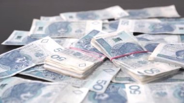 Masanın üzerinde birkaç banknot dosyası var. Masaya saçılmış para.