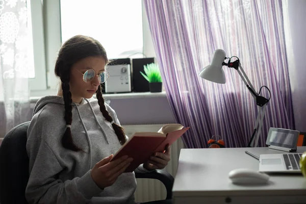 Підліток читає шкільне читання в її кімнаті вдома . — стокове фото