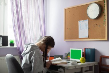 Yeşil ekran. Evde örgü ve gözlüklü bir öğrenci kitap okuyor..