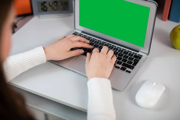 A green box on a laptop screen. Womens hands on laptop keyboard typing text. Proper use of the keyboard for a computer.