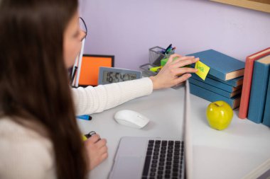 İngilizce öğrenmede açıklayıcı bir yöntem. Bir genç, üzerinde kitap yazan bir kart yapıştırıyor. Bireysel yabancı dil öğrenimi.