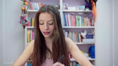 A young girl tells what blush she uses for her face and shows how to apply it. A young brunette with thick and long hair.