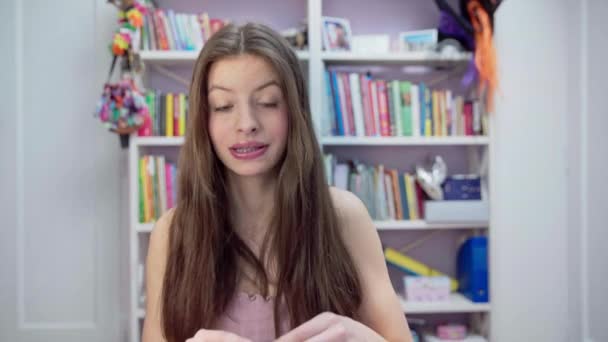 在她的视频博客中 精力充沛的少女讲述并展示了如何正确地画她的嘴唇 又年轻又友善 头发又厚又长的黑发姑娘 — 图库视频影像