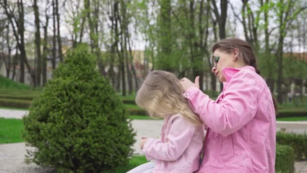 Uma Jovem Mãe Está Penteando Cuidadosamente Cabelo Loiro Suas Filhas — Vídeo de Stock