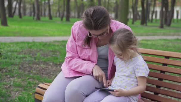 Girl Holds Smartphone Her Hands Mother Shows Her Daughter How — стоковое видео