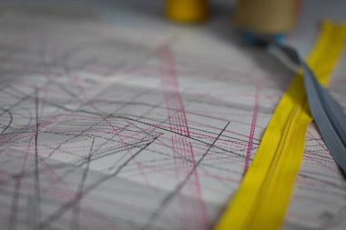 Close-up view of a paper sheet with garment blanks drawn in various sizes. Tailors workshop during selection of tailors blanks.