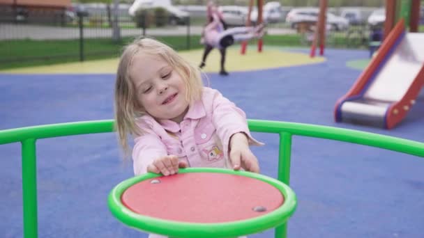 Fun Playground Game Spinning Carousel Little Girl Blonde Hair Tied — Stockvideo