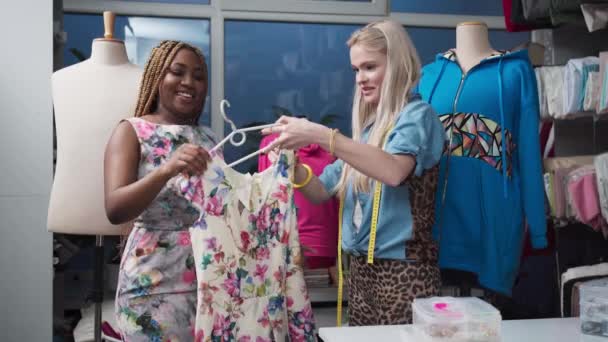 一位黑皮肤的顾客对一件花裙子感兴趣 正在试穿 一个地方的商店和裁缝店 — 图库视频影像