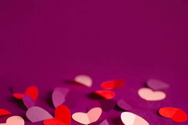 Close up pink purple red paper hearts on purple background. Happy Valentine Day. Greeting card. DIY Holiday and gift concept. Selective focus. Copy space — Stock Photo, Image