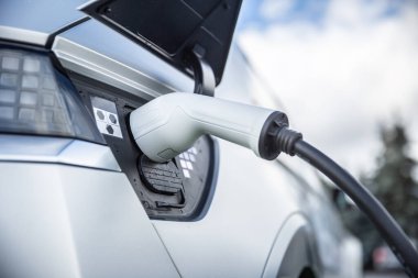 Hibrit bir arabanın elektrik prizine bağlı şarj edici..