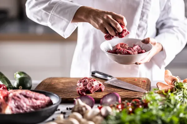 Detalj Röda Köttbitar Som Läggs Vit Skål Ett Matberedningsbord Fullt — Stockfoto