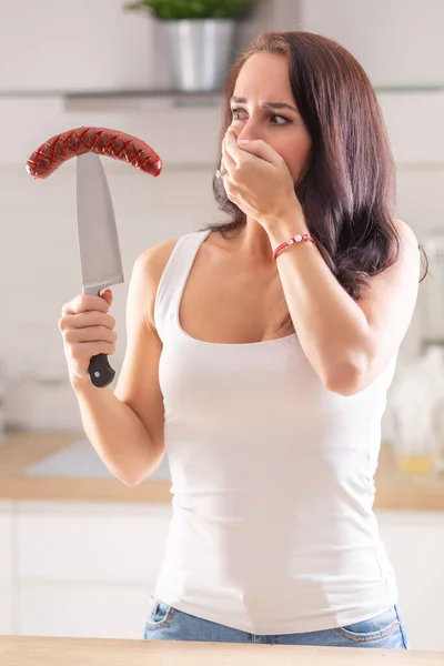 女人手里拿着刀顶住烤香肠 — 图库照片