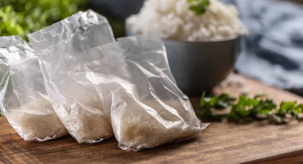 Rauwe Rijst Plastic Zakken Houten Achtergrond Gekookte Rijst Kom — Stockfoto