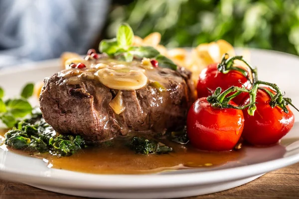 Cooked steak with peppercorn and sauce with healthy veg ready for serving.