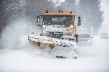 Liptov, Slovakya - 30 Ocak 2022. Kar küreme aracı arkadaki arabalara yol açıyor..