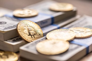 Amerikan banknotları üzerinde altın Bitcoinler. ABD para birimi ve kripto para birimi arasında çevrimiçi ticaret.