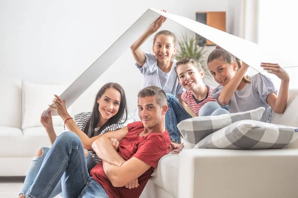 Három Gyermekes Család Boldog Egy Szimbolikus Tető Alatt Otthon Kanapén — Stock Fotó