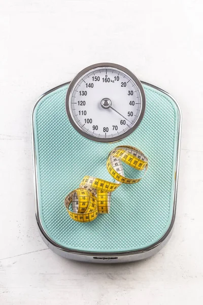 Weight scale with measure tape on floor - Top of view.