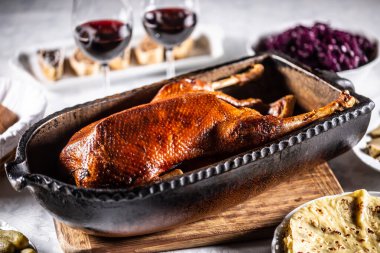 Goose feasts and roast goose in the oven on the festive table.