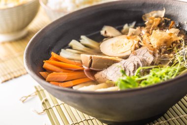 Japanese soup ramen with beef meat, egg and carrot on table in asian restaurant.