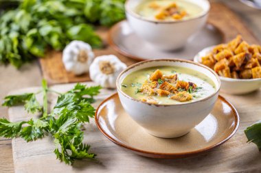 Garlic cream soup with bread croutons and flavored with copped celery leaves.