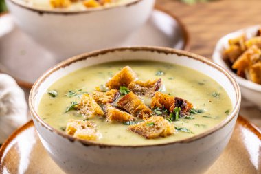 Garlic cream soup with bread croutons in rustic bowl - Close up.