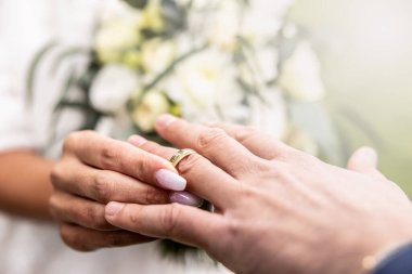 Gelin ve damadın elleri, Grrom 'un parmağına bir yüzük takarken.