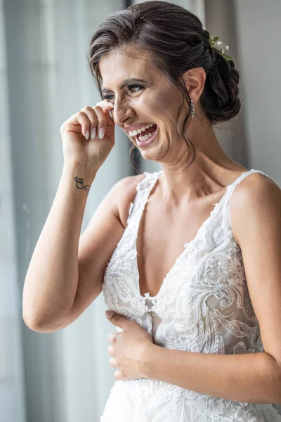 Bride crying the tears of joy and laughing, emotional on her wedding day.