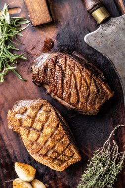 Biberiyeli ördek göğsü, kekik ve ahşap tepside kasap satır..