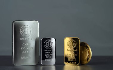 Kyiv, Ukrayna - 28 Mayıs 2020: İsviçre 'deki Argor-Heraeus fabrikası tarafından üretilen altın ve gümüş çubuklar ve Avustralya' daki Perth Mint 'in altın külçeleri. Gri bir arkaplanda.
