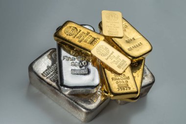 Kyiv, Ukrayna - 05 Aralık 2018: Farklı üreticilerden gelen çeşitli ağırlıklarda altın ve gümüş külçeler gri bir arka planda yatıyor.