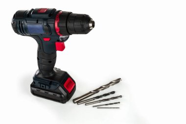Cordless drill and a set of different drills on a light background. 