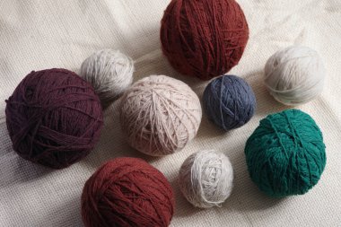 Kaba kumaşın arka planına karşı farklı renklerde iplik yumakları. Seçici odak.