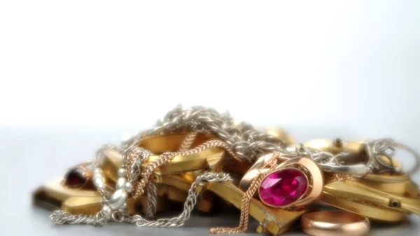 A scrap of precious metals In soft focus. Old and broken gold and silver jewelry, watches of gold and gold-plated lies in a pile. Selective focus.