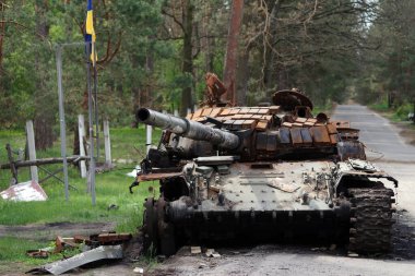 Mykolaivka, Bucha district, Kyiv region, Ukraine - April 28, 2022: The Ukrainian flag near the Russian tank was destroyed by the armed forces of Ukraine.