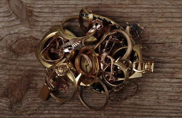 Old and broken jewelry, coins, watches of gold and gold-plated