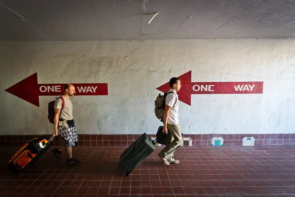 İki valiz ve yük arabaları ile yanlış yönde yürüme.