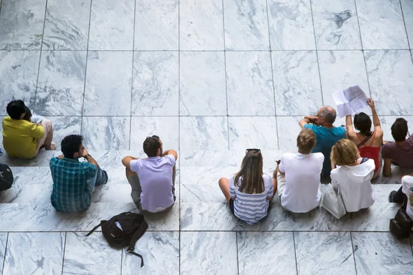 Pessoas sentadas em passos brancos Imagem De Stock